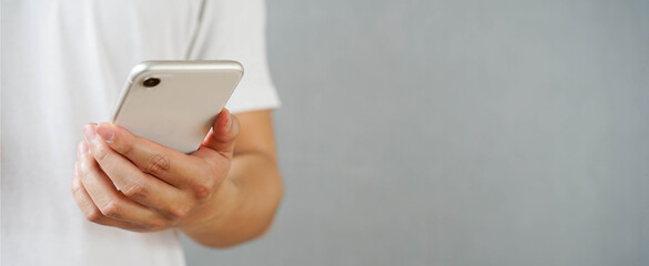 close up man hand hold mobile cell phone device for surf the internet or check news or play social media network application in relax time concept