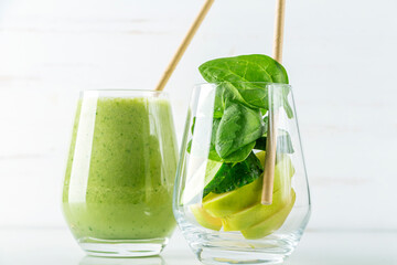 Glass with green smoothie and glass with ingredients spinach, apple, cucumber. Home cooking. Vegan healthy detox eating, dietary and weght loss drink