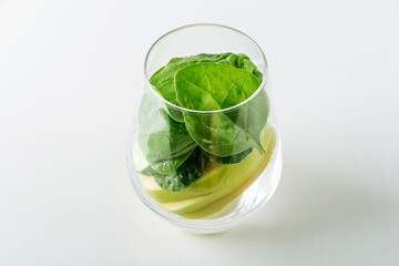 Glass with ingredients spinach, apple, cucumber for making green smoothie. Home cooking. Vegan healthy detox eating, dietary and weght loss drink