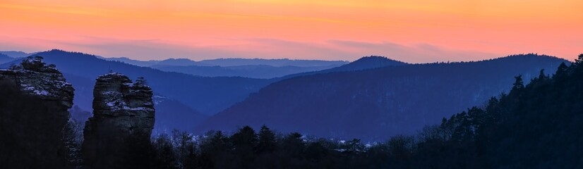 panorama of mountain layers during blue hour with beutiful orange sky, twilight, sky after sunset