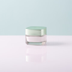 face cream in a glass container on a white-blue background