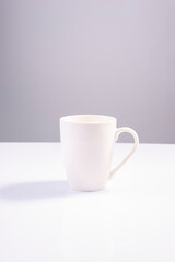 Fototapeta na wymiar empty white cup on white gray background minimalistic concept