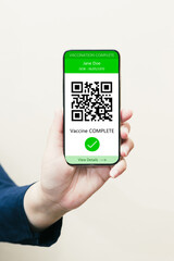 Woman's hand showing passport for COVID-19 vaccine displayed on a smartphone screen. Concept of coronavirus vaccination campaign for health.