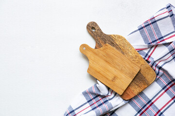 Kitchen concept - wooden cutting boards and towels on a white background, top view, flat