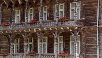 Fototapeta na wymiar Wooden old facade of the house. Facade of the old log house in the of wooden architecture.