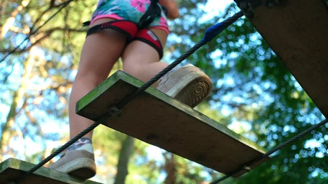 Young Caucasian Girl Walking Carefully on Plank Bridge in Rope Park Slow Motion