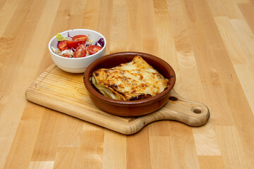Great cheese lasagna with layers of pasta, béchamel gratin with more grated cheese and a side tomato and cabbage salad