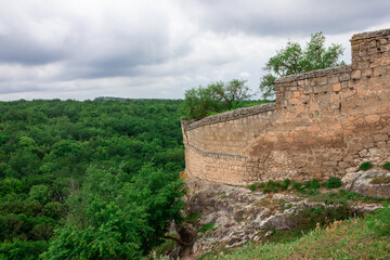 A stone fence over a cliff. The old wall of the medieval city.