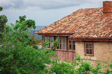 A balcony in an old house. The tiled roof of the building.
