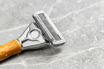 Shaving Razor with wooden handle on a grey marble