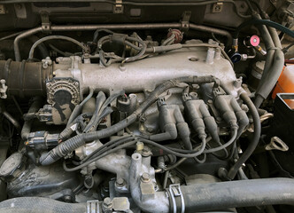 Fototapeta na wymiar Car gasoline engine. Car engine part. Close-up photo of an internal combustion engine. Engine detailing in a used car.