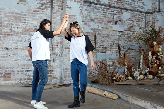 Two event coordinators celebrating by doing a high five