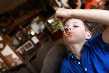 Child eating spaghetti with his hands