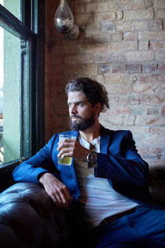 Hipster man enjoying drinking a beer at pub