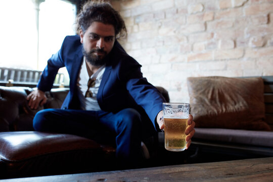 Hipster man enjoying drinking a beer at pub