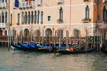 Fototapeta na wymiar Traditional Venetian gondolas moored on Grand Canal in Venice, Italy
