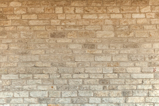Cream and white brick wall texture background. Brickwork or stonework flooring interior rock old pattern stone design stack. limestone natural briks wall