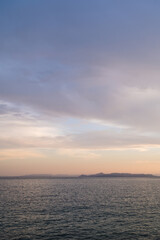 Beautiful landscape of sunset over Aegean sea in Athens, Greece. Calm water. Silhouettes of islands.