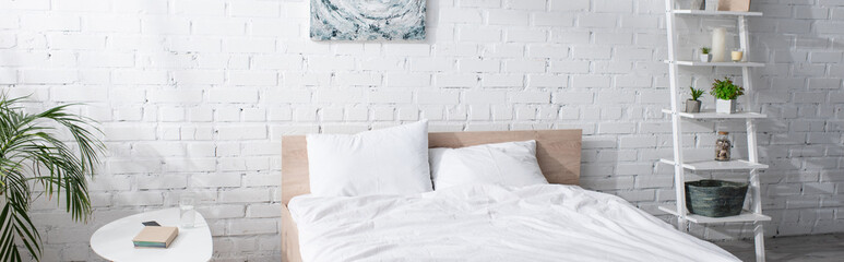 bed with white bedding in modern bedroom, banner