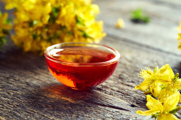 Red oil made from St. John's wort flowers on a table