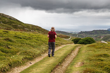 A single female on a ramble along the mountain track on the scenic Wales Coastal Path at...