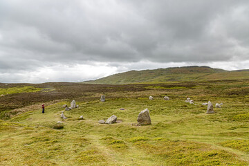 A single female using her phone at the Neolithic Site commonly referred to a Druid Circle near...