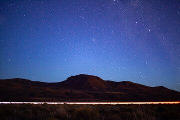 Car passing on the road and sky full of stars and milky way at night