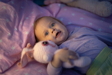 baby one year old lies in bed with