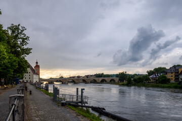 REgensburg historische, steinerne Brücke ,Dom und Brückturm im Sommer am abend mit Sonnenuntergang