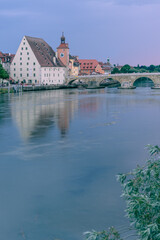 REgensburg historische, steinerne Brücke ,Dom und Brückturm im Sommer am abend mit Sonnenuntergang