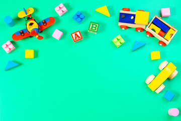 Baby kid toy background. Set of colorful educational wooden children toys on light green background. Top view, flat lay