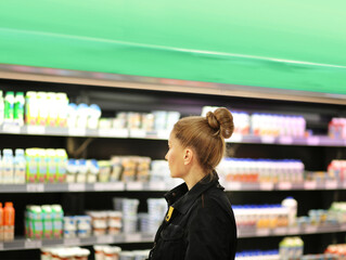 Woman choosing a dairy products at supermarket