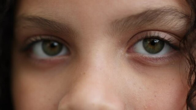 Child macro eyes close-up looking at camera, little girl kid staring closeup