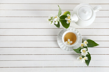Fototapeta na wymiar Jasmine flowers and teapot on white wooden background. Herbal tea of jasmine flower. Flat lay.