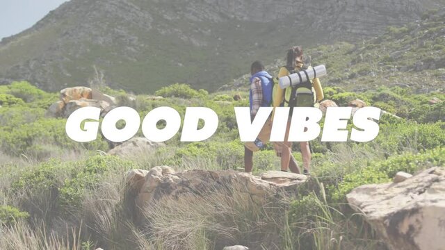 Animation of the words good vibes written in white over couple hiking in mountains drinking water