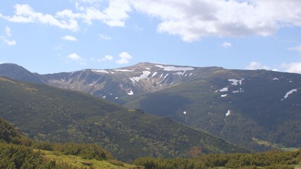 Fototapeta premium View of the mountain of the Montenegrin ridge. There is snow on the mountain, the growth of a tree. Place of the hiking trail.