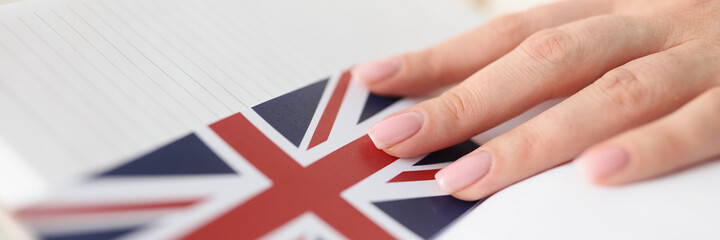 Woman holding diary with bookmark in form of flag of england closeup