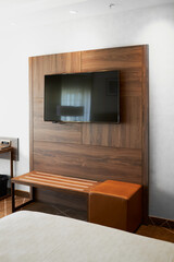 Modern hotel bedroom with a TV and work desk