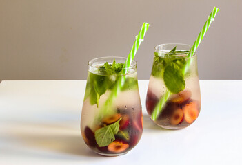 Cold drinks in a glass. Cherries mint lemonade. Mojito coctail. Summer iced refreshment drink.