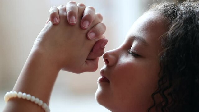 Little girl praying to God, spiritual child in prayer