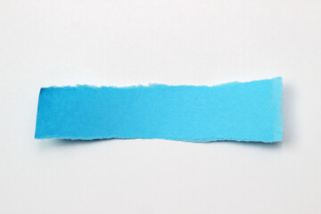 A torn strip of blue paper on a white background. Space for text
