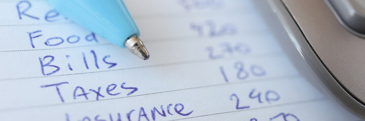 Ballpoint pen lying on expense list closeup