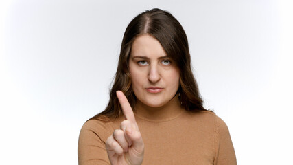 Portrait of young woman saying no by shaking index finger. Concept of ban, prohibition and taboo.