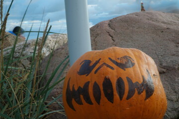 Halloween K&uuml;rbis vor einem Stein am Strand