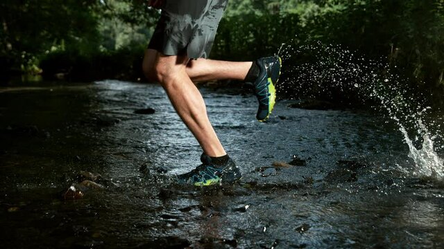 Super slow motion of man foot running in river, splashing around. Speed ramp effect. Filmed on high speed cinema camera, 1000 fps.