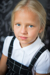 interesting  little girl in school clothes against a school board with drawings on the theme of School.  School concept. Back to school.