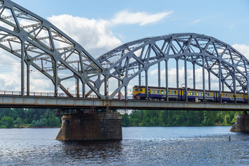 The train crosses an old railway bridge
