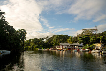 Fishing boats on the banks of the Chuspa river in the Vargas state of Venezuela on a sunny day in front of the coastal mountain