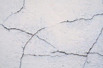 Old white paint cracking on the wall of the building.