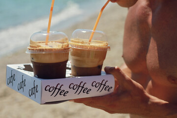 Man drinking ice coffee close up. Refreshment on the beach